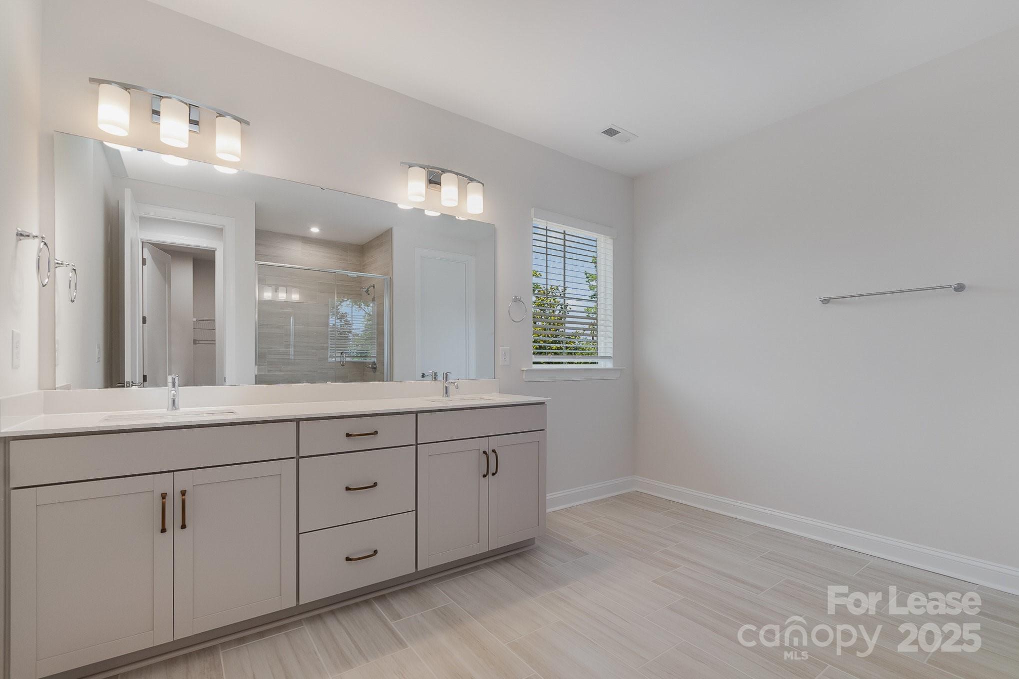 3224 Everly Enclave Way Charlotte, NC 28210 - Photo 15 of 24 a bathroom with a double vanity sink and a mirror