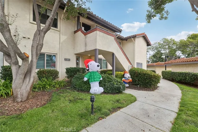 a front view of a house with a yard and potted plants