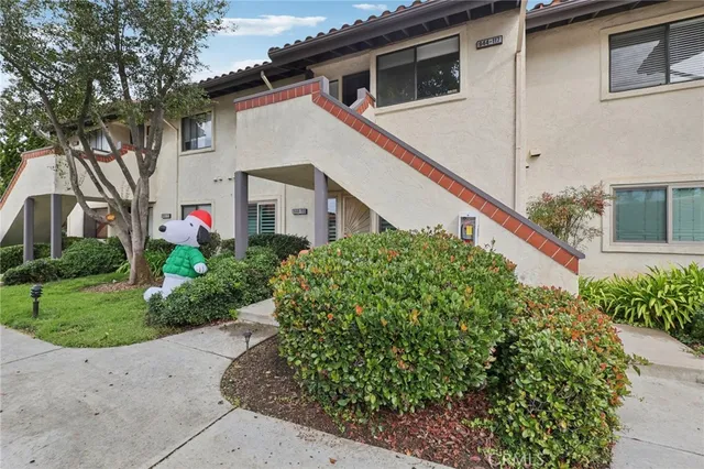 a front view of a house with a yard and potted plants