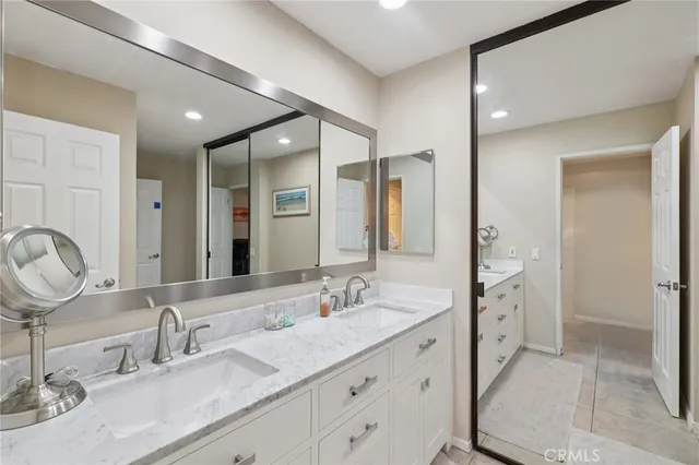 a bedroom with a bed a couch and a chandelier