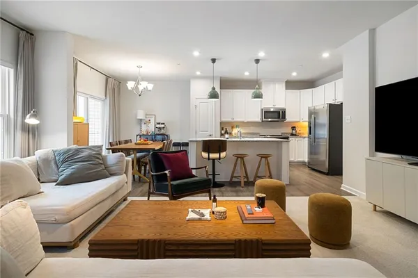 a living room with furniture kitchen view and a flat screen tv