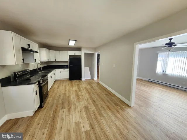 a view of a kitchen with a sink and wooden floor