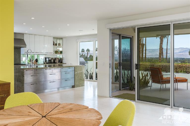 70288 Calico Road Rancho Mirage, CA 92270 - Photo 9 of 20 a kitchen with stainless steel appliances kitchen island granite countertop a refrigerator a sink a dining table and chairs