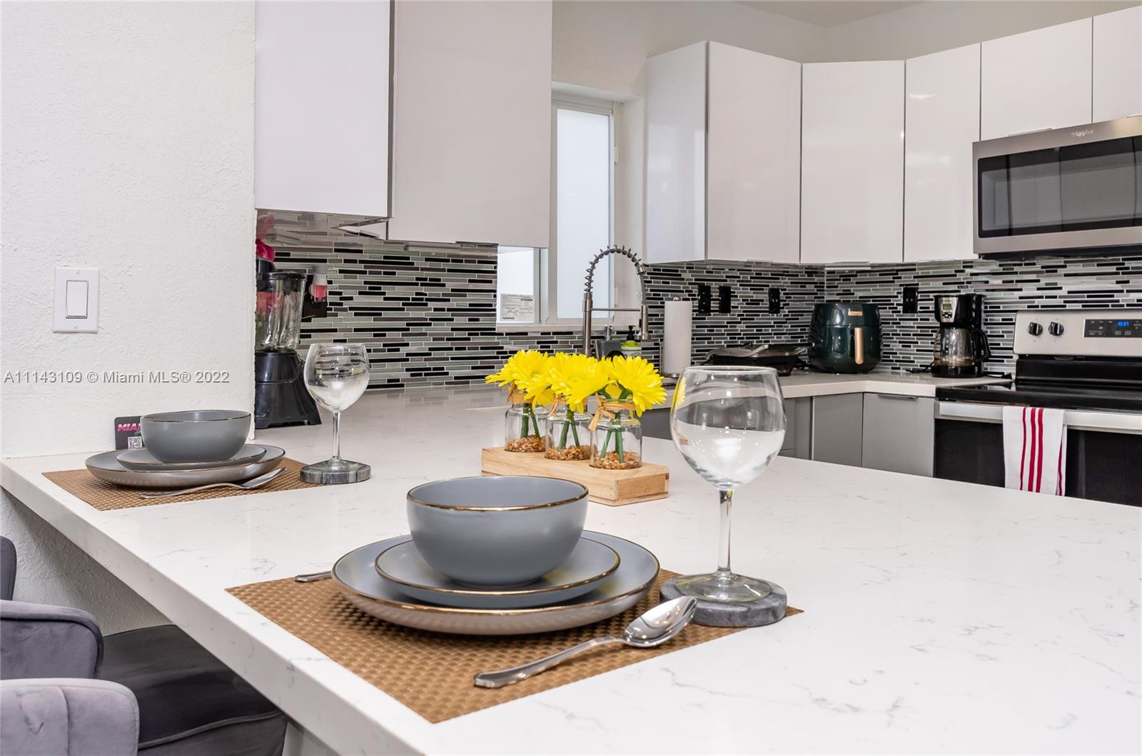 231 Northwest 44th Street Miami, FL 33127 - Photo 22 of 63 a kitchen with a stove a sink and a white cabinets