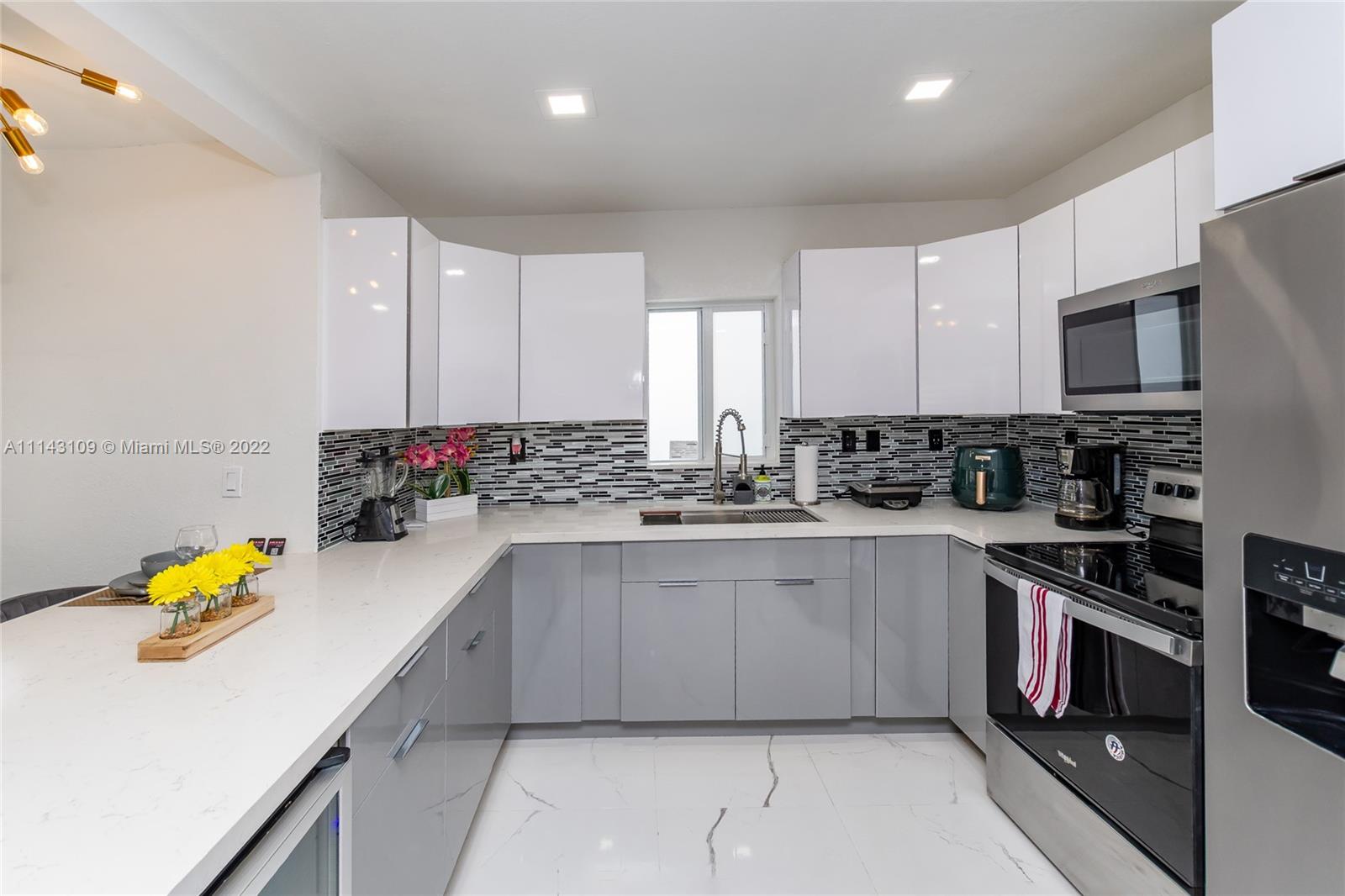 231 Northwest 44th Street Miami, FL 33127 - Photo 24 of 63 a kitchen with stainless steel appliances white cabinets sink and stove