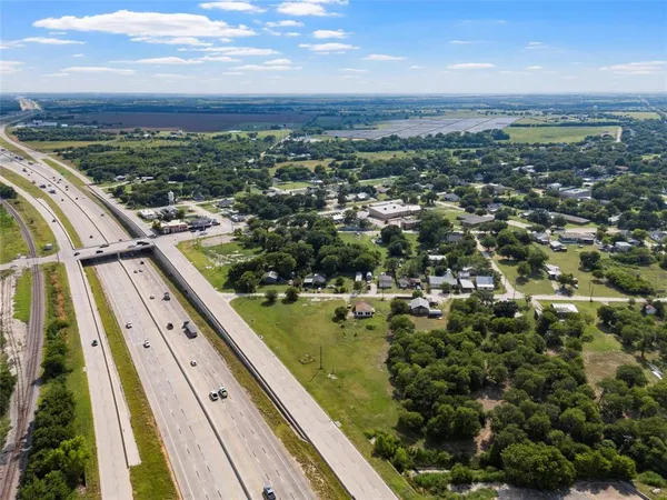 an aerial view of residential houses with outdoor space and trees
