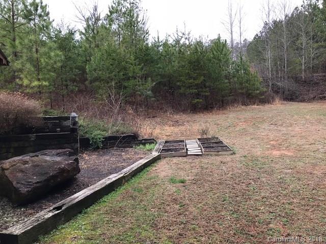 139 Stanley Ln Mill Spring, Unit 8 Mill Spring, NC 28756 - Photo 20 of 22 a view of a backyard with lawn chairs and a fire pit