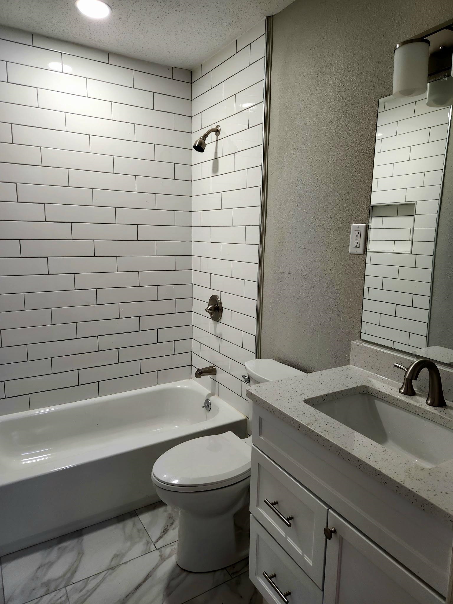 866 Colonial Road Memphis, TN 38117 - Photo 11 of 15 Full bath featuring a textured wall, vanity, shower combination, light marble finish flooring, and a textured ceiling