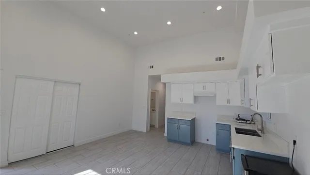 a kitchen with granite countertop white cabinets and stainless steel appliances