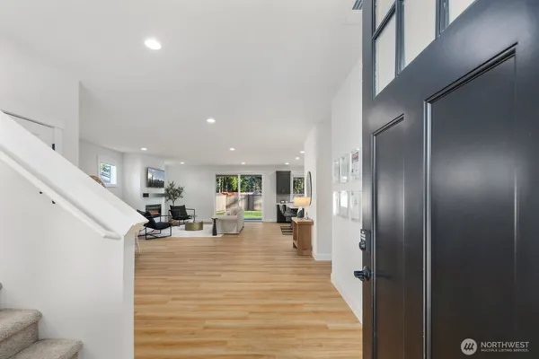a living room with furniture a flat screen tv and kitchen view