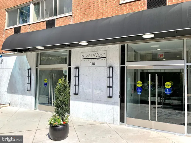 a front view of a building with glass windows and a potted plant