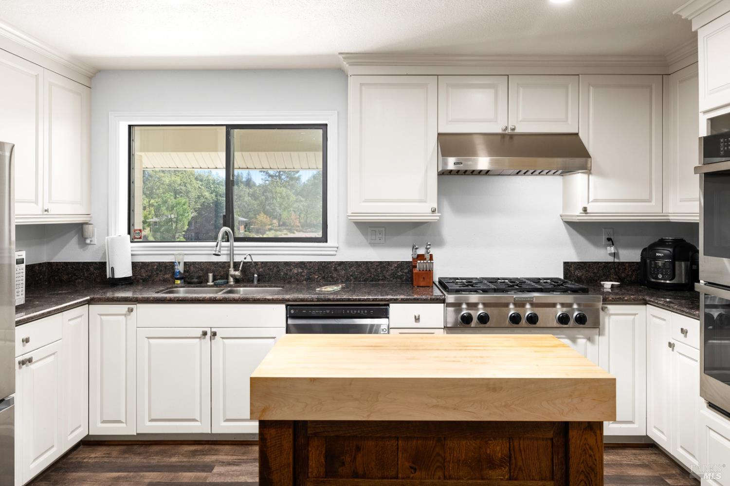 875 White Cottage Road North Angwin, CA 94508 - Photo 37 of 59 a kitchen with granite countertop a stove a sink a refrigerator and white cabinets with wooden floor