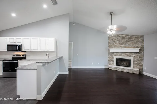 a kitchen with a sink wooden floor and a fireplace