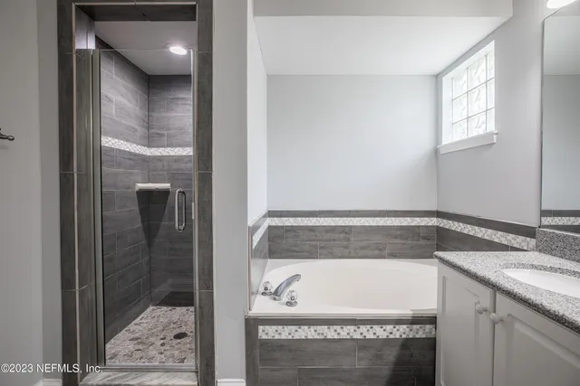a bathroom with a tub a sink and a mirror