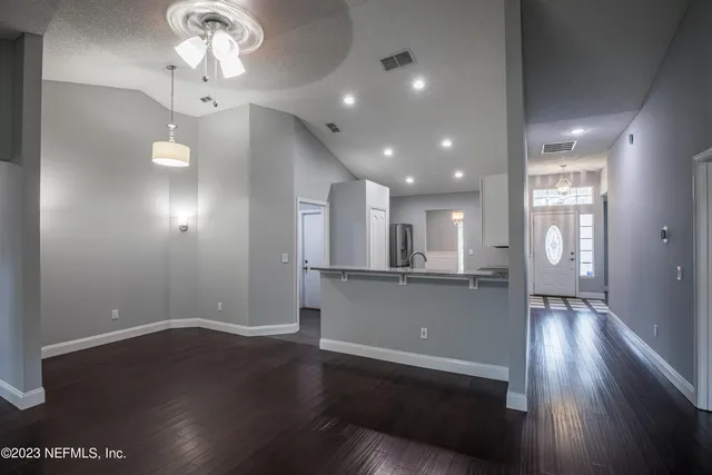 a view of a room with wooden floor and a ceiling fan