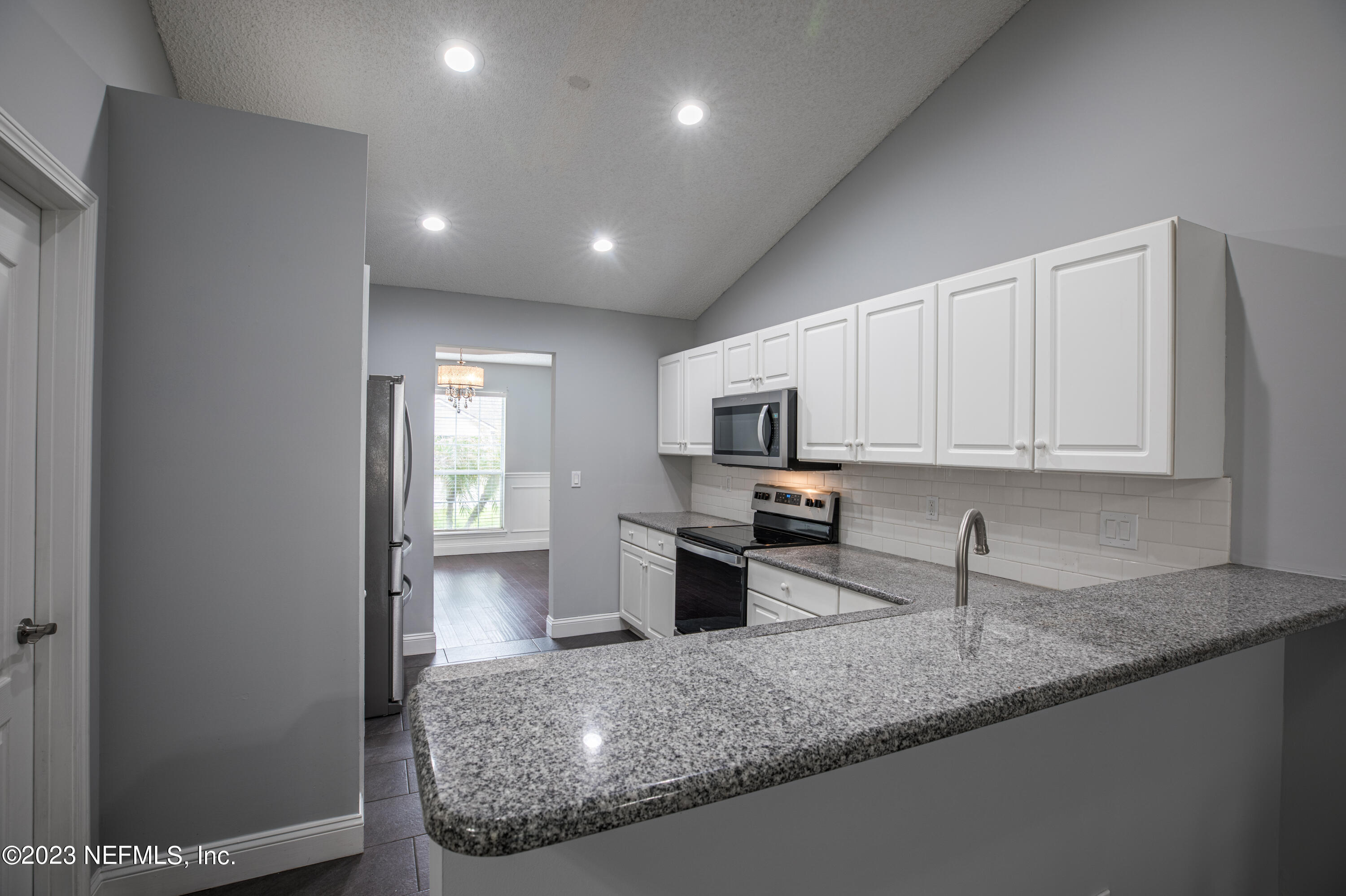 13607 Capistrano Drive South Jacksonville, FL 32224 - Photo 9 of 24 a kitchen with stainless steel appliances granite countertop a sink refrigerator and microwave