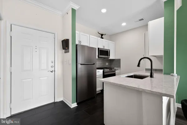 a living room with furniture kitchen view and a large window
