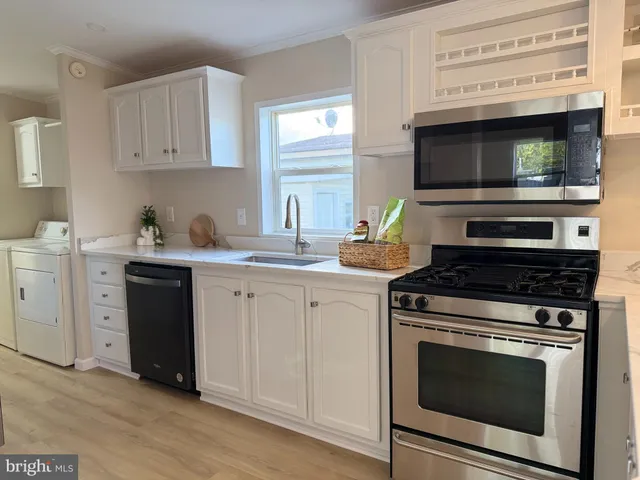 a kitchen with stainless steel appliances a stove a sink and a microwave