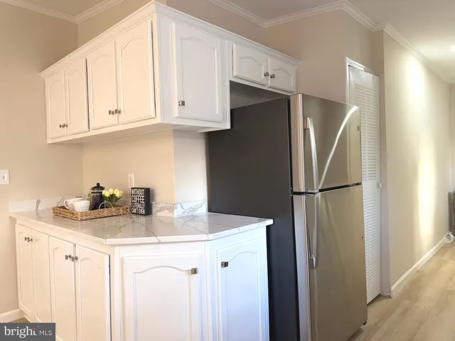 a kitchen with stainless steel appliances white cabinets and a refrigerator