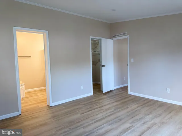 an empty room with wooden floor and closet