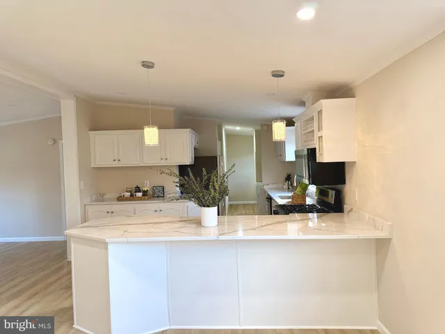 a kitchen with stainless steel appliances a sink a stove a microwave a counter top space and cabinets