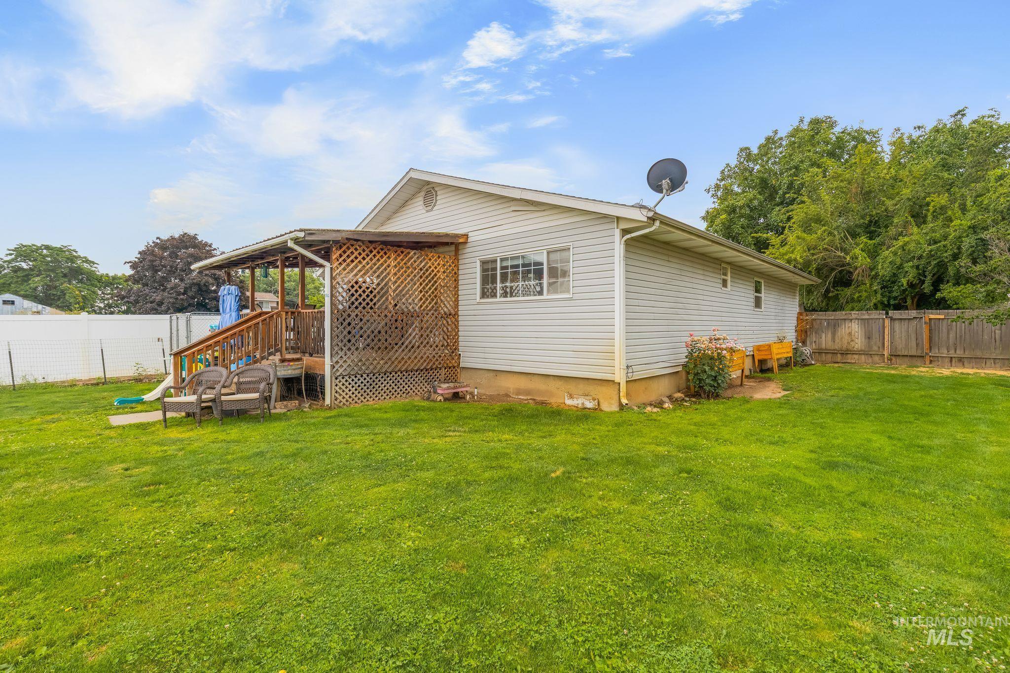 2119 Ripon Avenue Lewiston, ID 83501 - Photo 31 of 50 Expansive backyard featuring a covered wooden deck with lattice skirting, a white vinyl fence, and a natural wood privacy fence