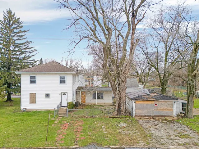 a white house that has a tree in front of it