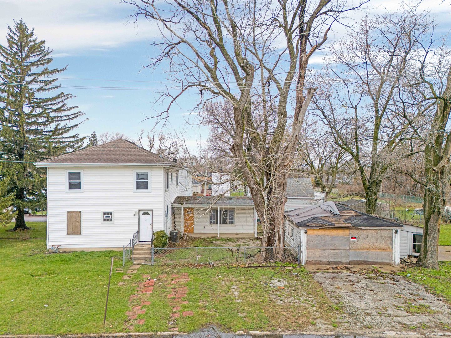 a white house that has a tree in front of it