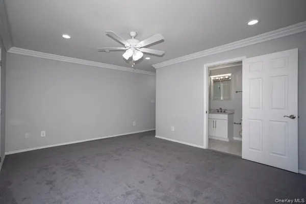 an empty room with closet and a ceiling fan