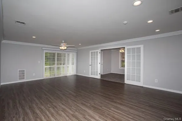 an empty room with wooden floor and windows