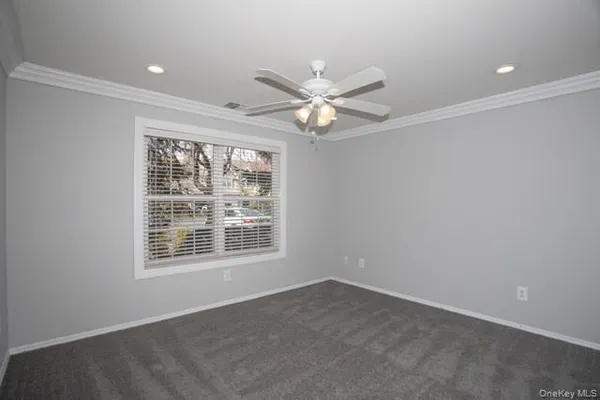 an empty room with a window and a fan