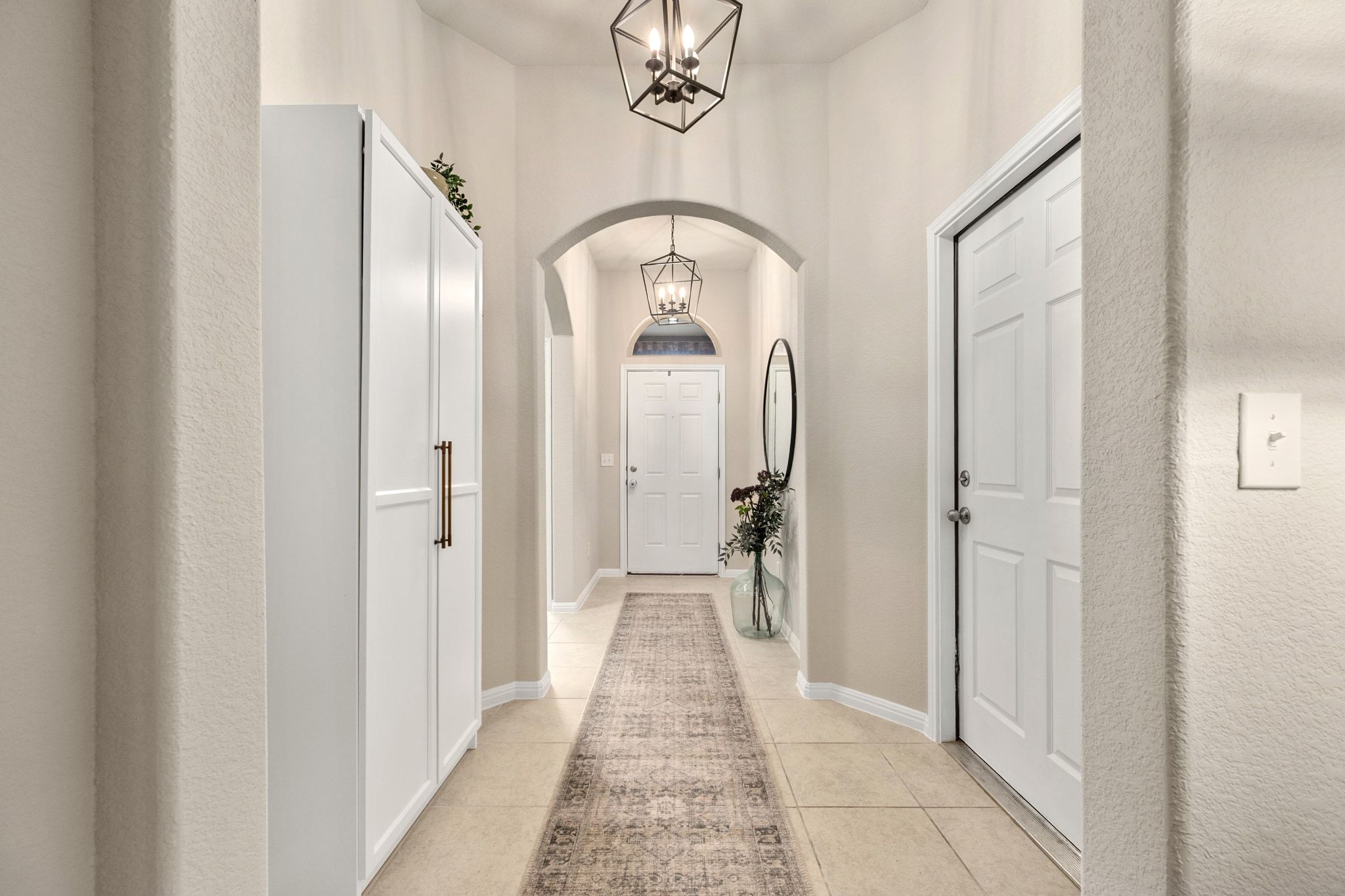 109 Findley Avenue Leander, TX 78641 - Photo 3 of 38 Upon entry the arched walkway continues with a show-stopping hall and luxe chandeliers.