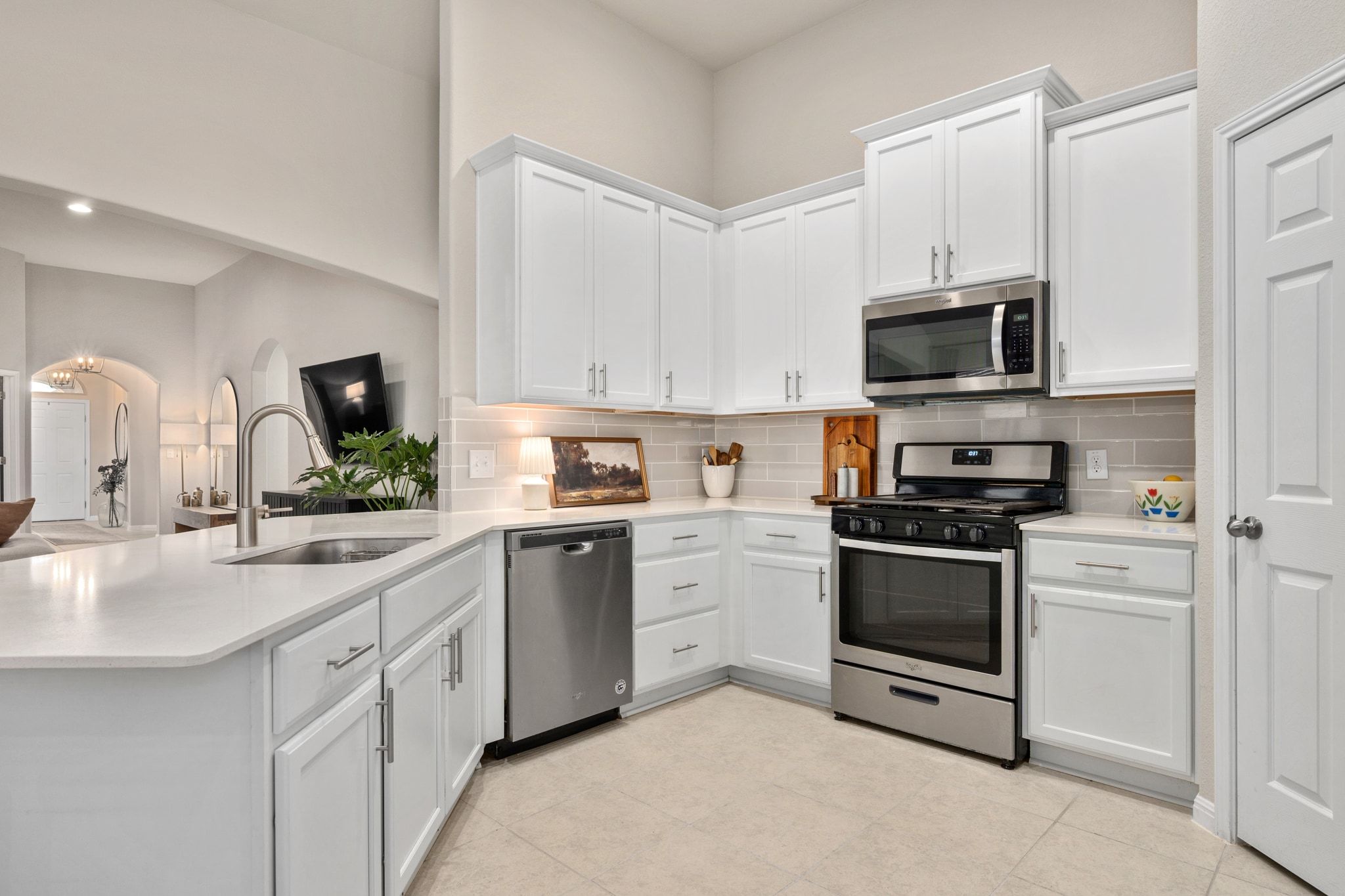 109 Findley Avenue Leander, TX 78641 - Photo 10 of 38 The kitchen boasts stainless steel appliances, white shaker cabinetry, decorative backsplash, a peninsula, and light stone counters.