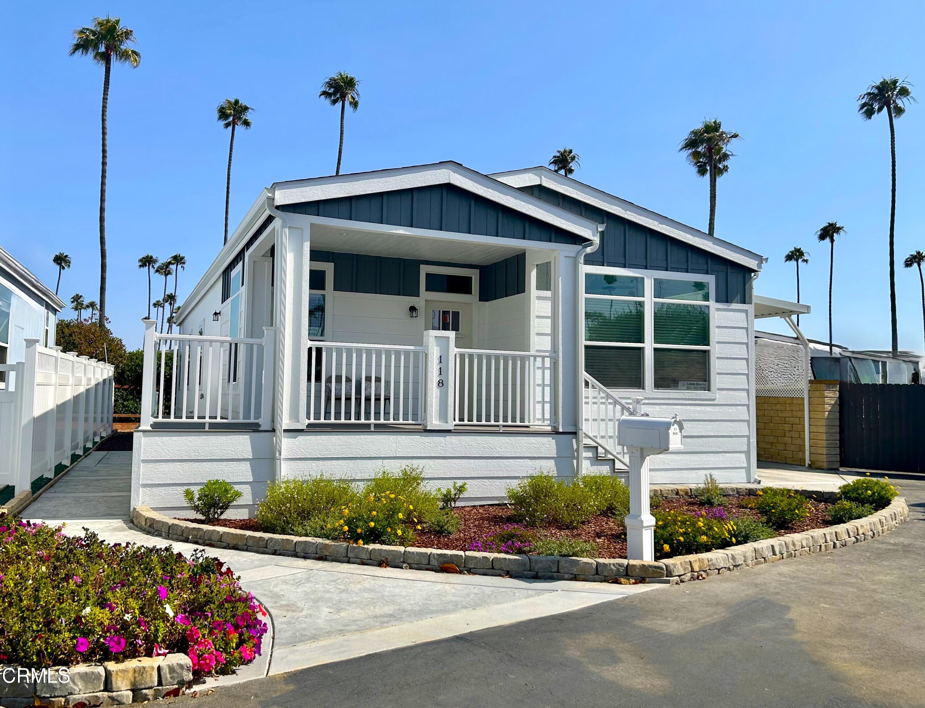 a front view of a house with a yard and potted plants