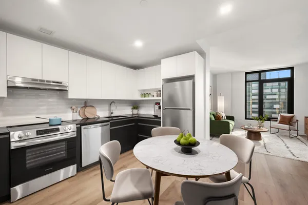 a kitchen with stainless steel appliances kitchen island a table and chairs