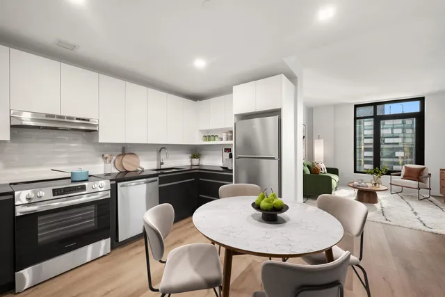 a kitchen with stainless steel appliances kitchen island a table and chairs