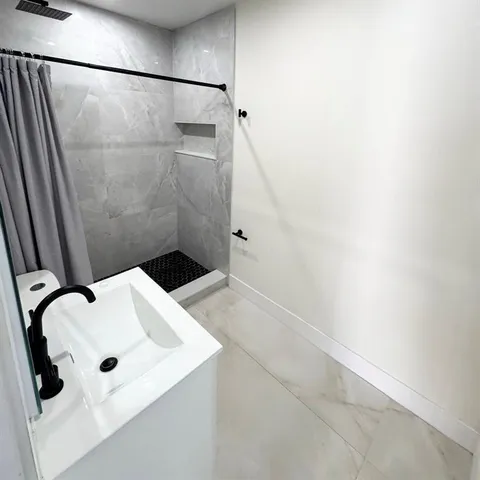 a bathroom with a sink toilet and shower