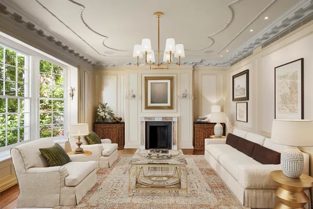 a living room with furniture a fireplace and a chandelier