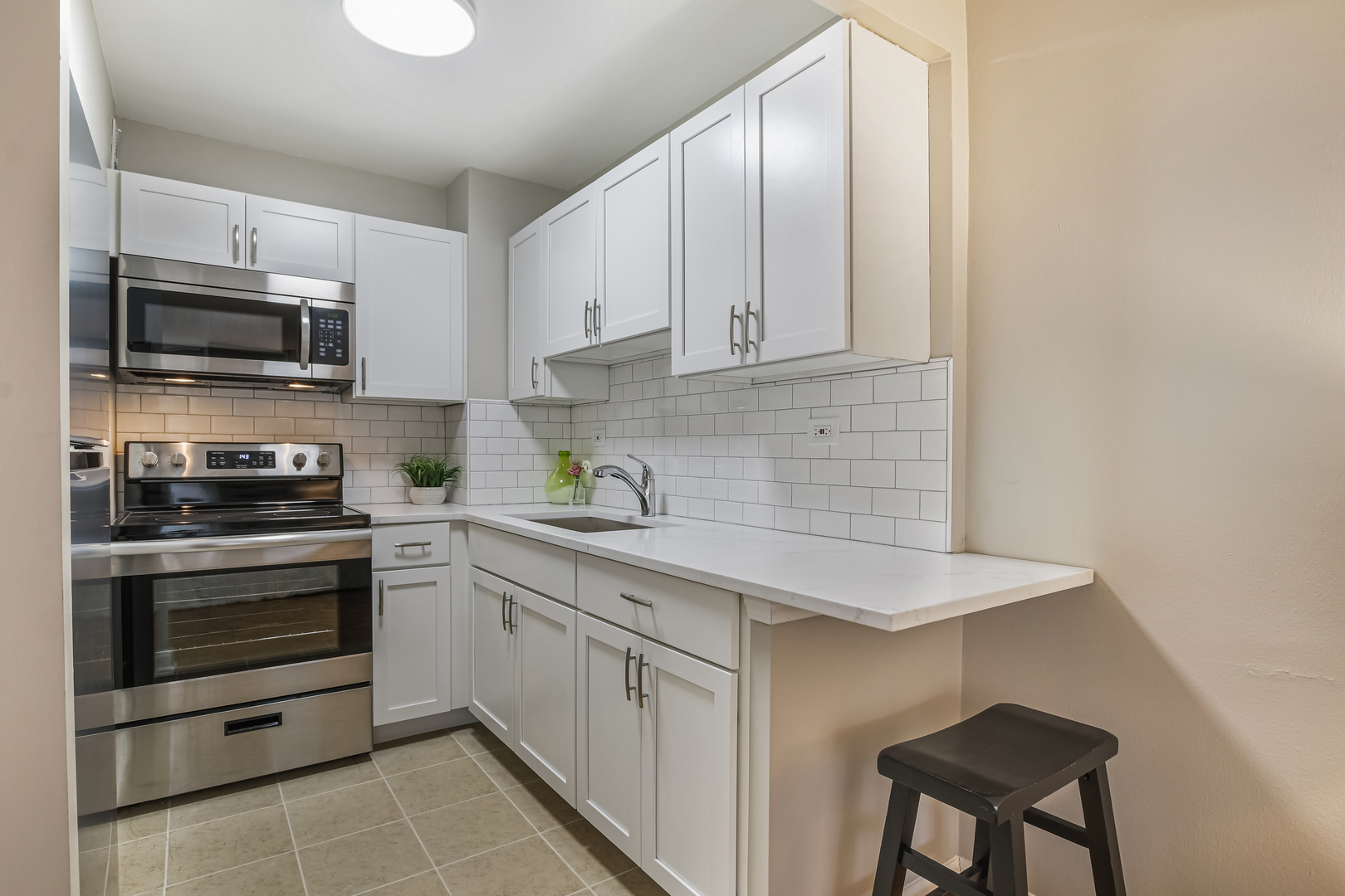 21 West Goethe Street, Unit 14D Chicago, IL 60610 - Photo 13 of 28 a kitchen with stainless steel appliances a stove a sink and white cabinets