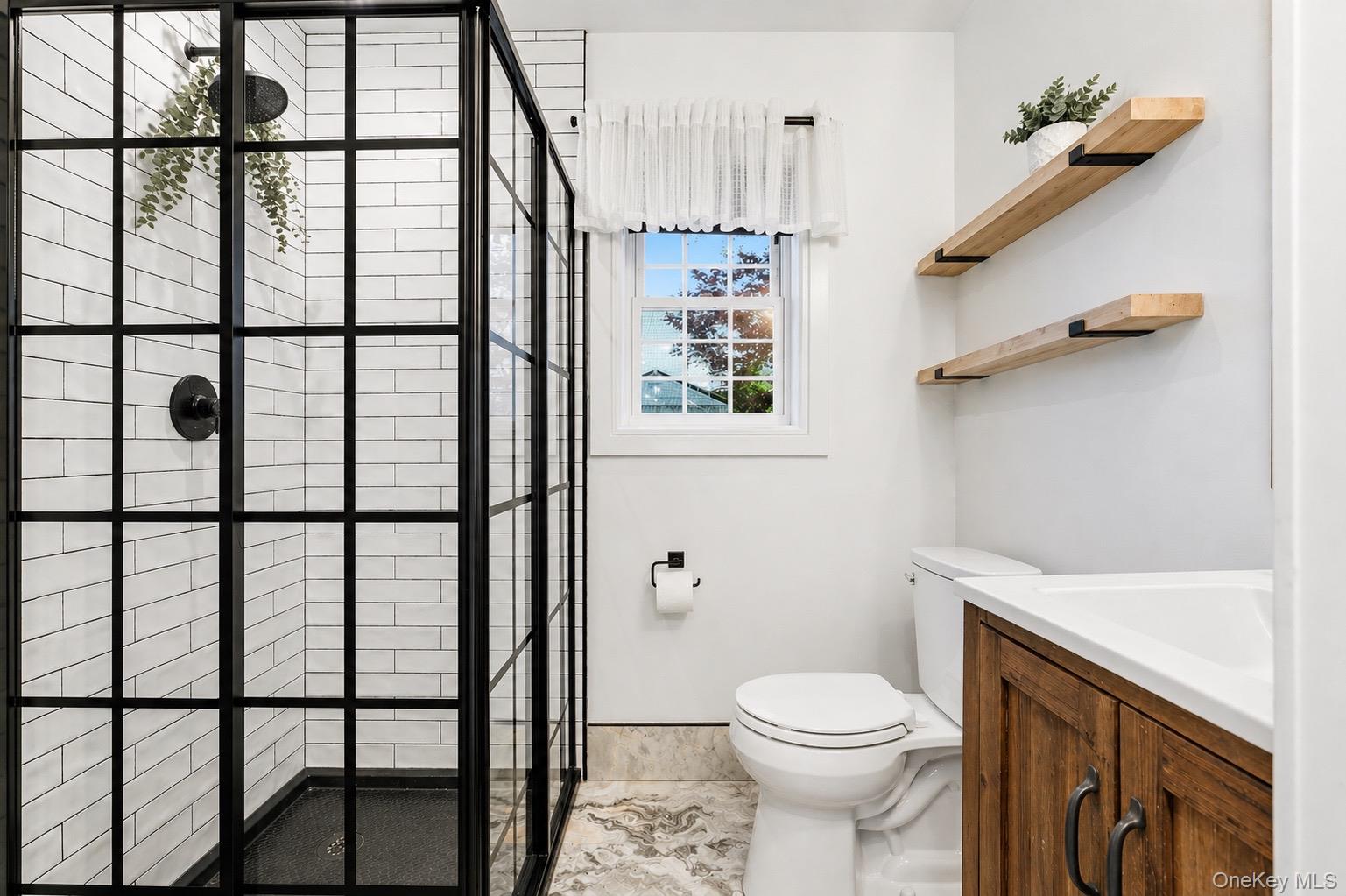 18 Pond Road Holbrook, NY 11741 - Photo 14 of 41 Modern bathroom featuring a black-framed glass shower enclosure with subway tile surround and matte black fixtures
