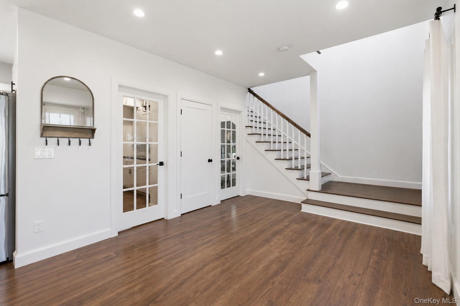 18 Pond Road Holbrook, NY 11741 - Photo 16 of 41 Staircase with dark wood handrail, recessed lighting, and white paneled doors.