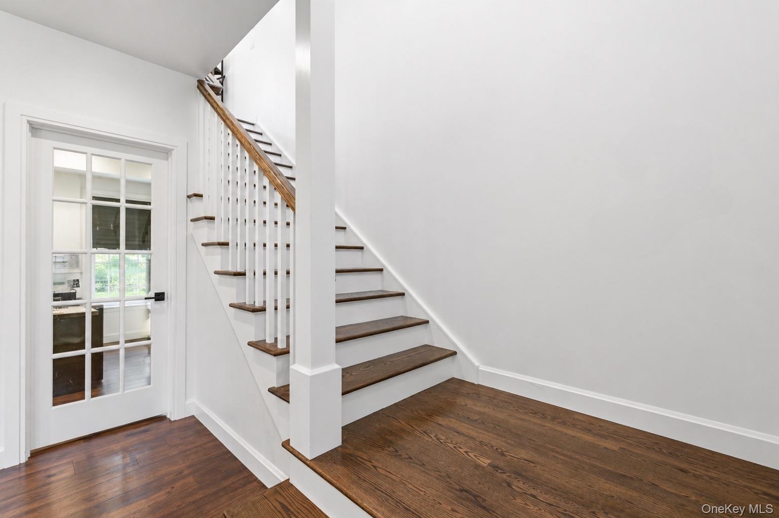 18 Pond Road Holbrook, NY 11741 - Photo 17 of 41 Entryway featuring wood-finish flooring, a staircase with white risers and wood treads, a matching wood handrail, and white balusters