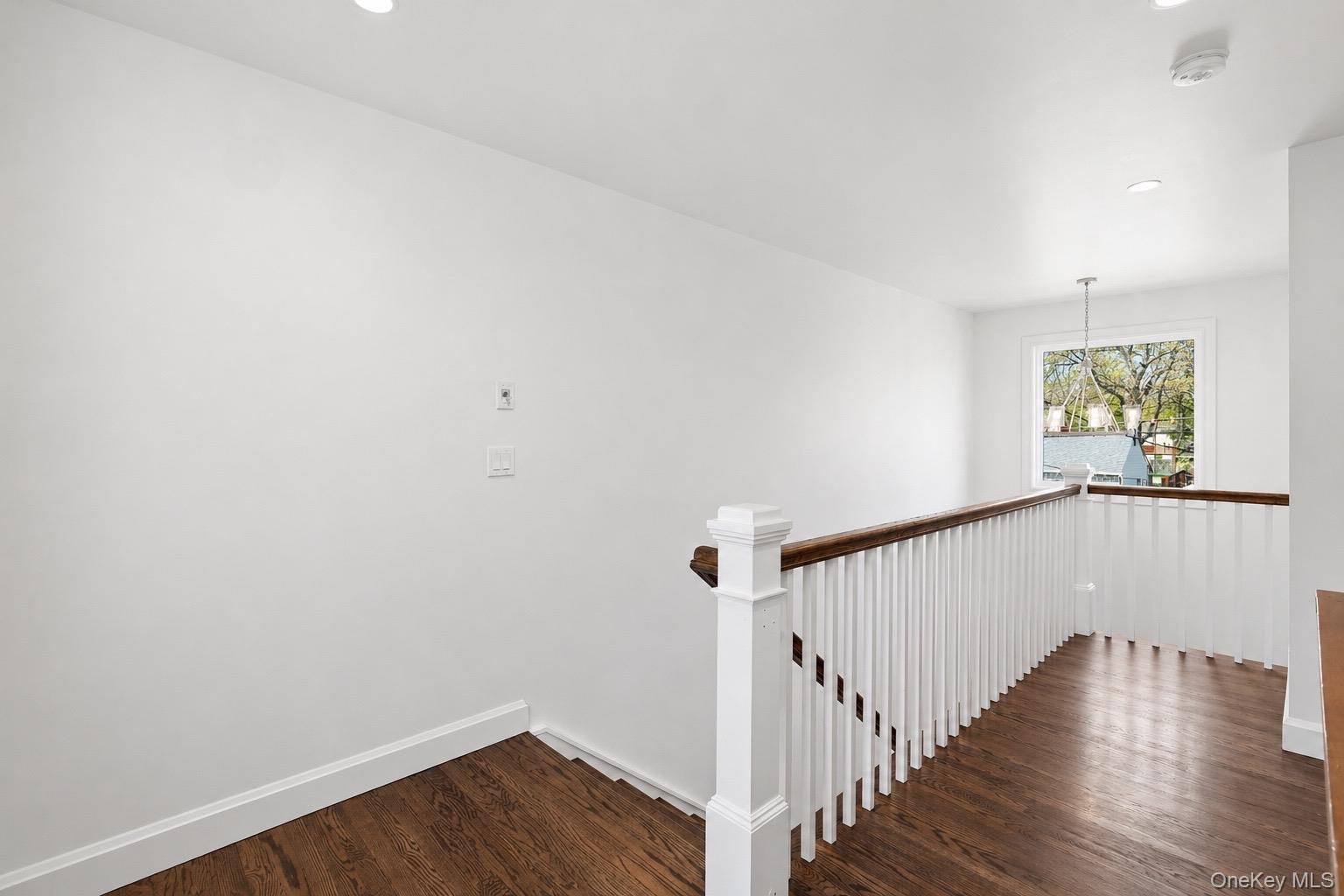 18 Pond Road Holbrook, NY 11741 - Photo 18 of 41 Hardwood flooring and white balusters with a dark wood-finish handrail