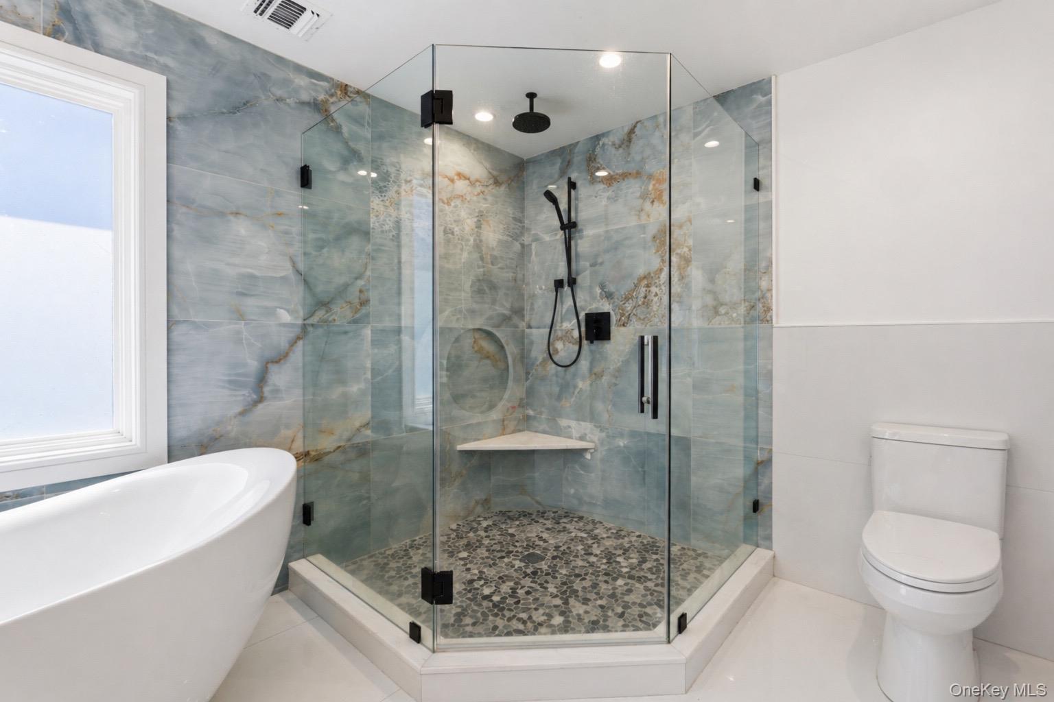18 Pond Road Holbrook, NY 11741 - Photo 21 of 41 Spacious Primary bathroom featuring a frameless glass shower enclosure with pebble flooring, integrated bench, and matte black fixtures