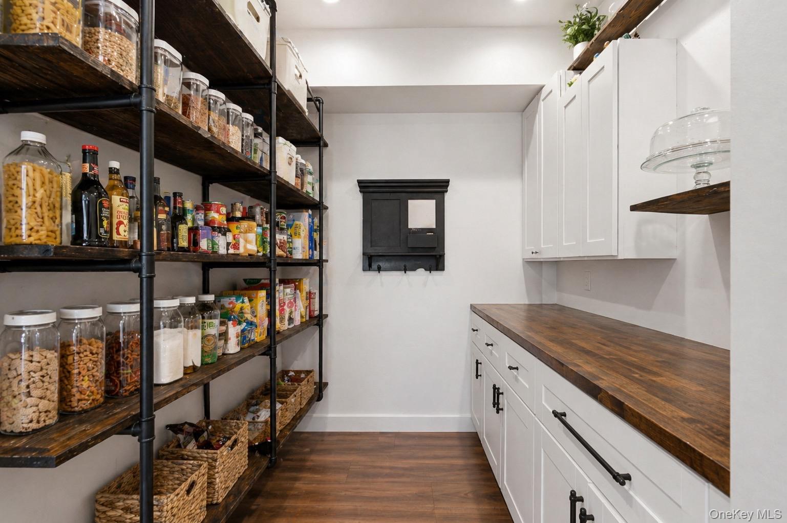 18 Pond Road Holbrook, NY 11741 - Photo 6 of 41 Custom pantry featuring extensive open shelving with dark wood-finish shelves and black pipe supports, complementing white cabinetry with matte black hardware