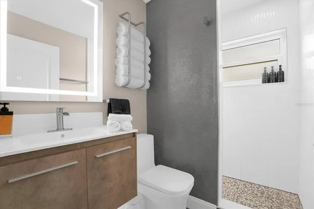 a bathroom with a toilet sink vanity and mirror