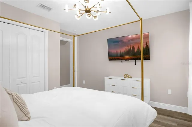 a bedroom with a bed and a flat screen tv