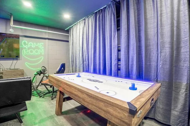 a room with pool table and windows