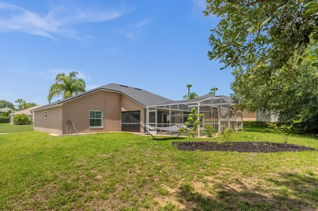 a white house with a big yard and large trees