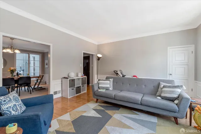 a dining room with furniture a chandelier and wooden floor